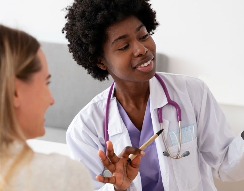 Médica residente ao lado de colega analisa radiografia durante atendimento