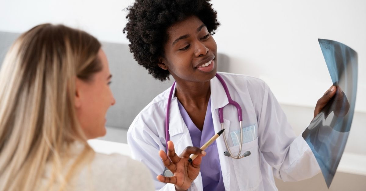 Médica residente ao lado de colega analisa radiografia durante atendimento