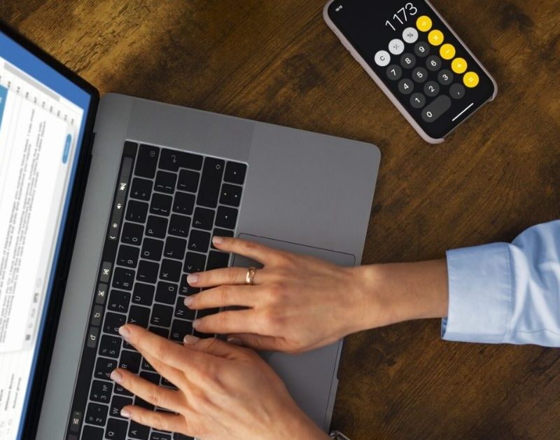 Profissional usando notebook e calculadora para organizar a contabilidade médica e o planejamento financeiro