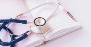 Estetoscópio sobre planner representando a organização do livro caixa para médicos e despesas do consultório