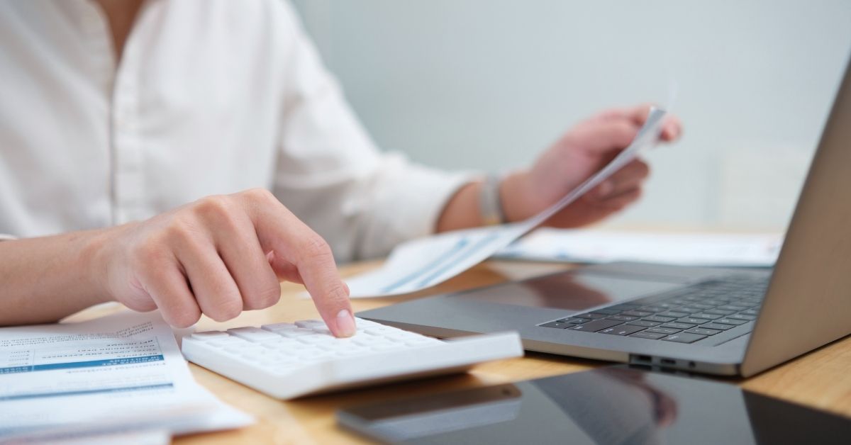 Profissional analisa documentos e faz cálculos para avaliar se vale a pena adotar o Simples Nacional híbrido em 2027