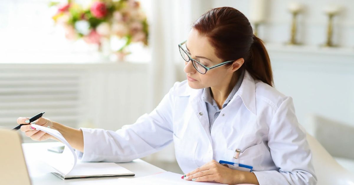 Médica de jaleco analisando documentos em uma mesa de trabalho, ilustrando a dúvida se médico pode ser MEI.